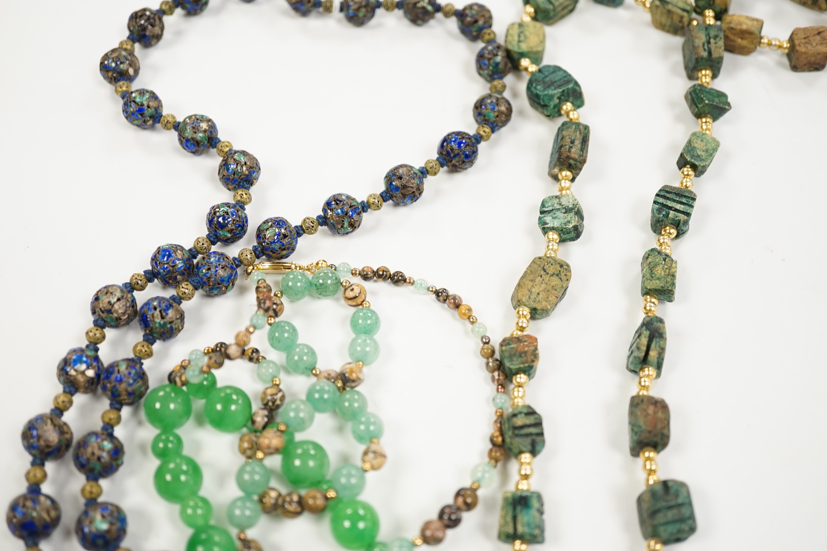 Three assorted Chinese bead necklaces including filigree gilt white metal and enamel pendant necklace, overall 68cm and a jade bracelet.